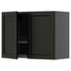 A dark green METOD kitchen wall cabinet with one open door revealing a wire dish drainer.