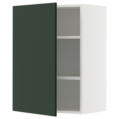 A white wall cabinet with a green door slightly open, revealing adjustable gray shelves inside. Part of METOD kitchen system.