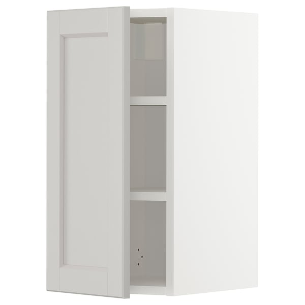 A white METOD kitchen cabinet with light grey lerhyttan fronts and adjustable shelves.