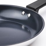 Close-up of high-quality frying pan with smooth, dark non-stick interior and robust black handle.