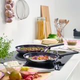 MIDDAGSMAT frying pans cooking on modern stovetop, surrounded by fresh ingredients and kitchen tools.