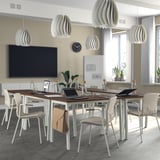 MITTZON conference table with pendant lights, laptops, and chairs. Wooden top, white legs, big screen, and natural light from windows.