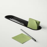 Black pen holder with green sticky notes and pen. One note reads please call boris.