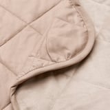 Close-up of quilted velvet bedspread, soft texture visible.