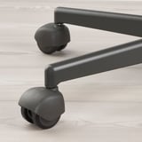 Close-up of durable office chair wheels on light wood floor. Sturdy design, robust grey castors shown.