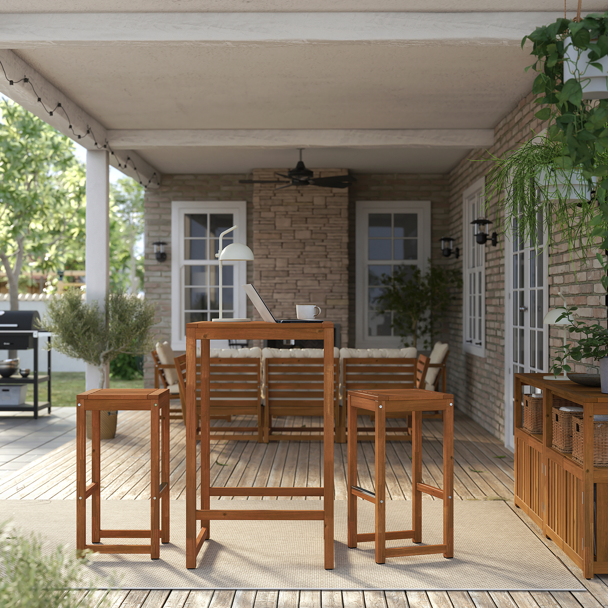 Outdoor patio with NÄMMARÖ brown wooden table, stools, and bench, good for dining or working.