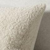 Soft, plush cushion; beige, recycled polyester; fluffy, inviting texture.