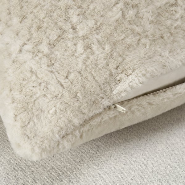 Close-up of soft, plush beige pillow cover with visible zipper, highlighting its supersoft texture and quality.