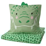 Green dinosaur-shaped pillow & matching bedding set with spotty pattern.