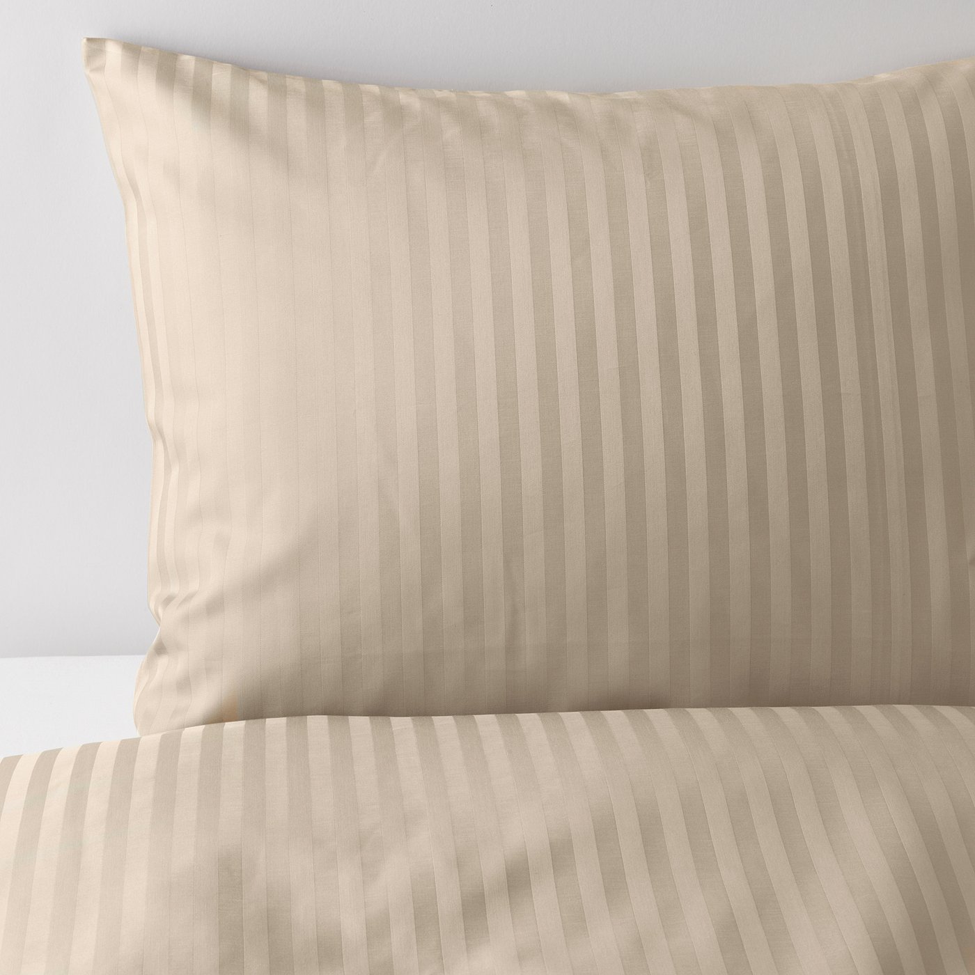 Close-up of crisp, beige striped bedding set with subtle sheen, showcasing smooth, soft fabric.