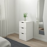 A white NORDLI 3-drawer chest against a mirror, vase with greenery, wall-safe.