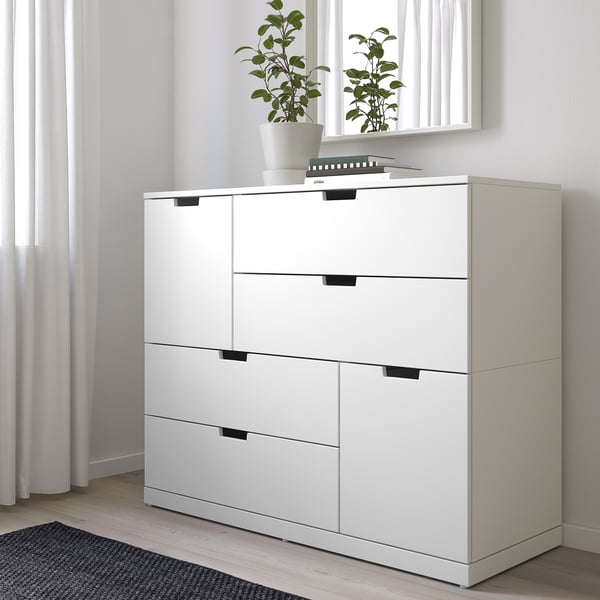 White NORDLI dresser with 6 drawers, sleek modern design, fits under window, plants atop.