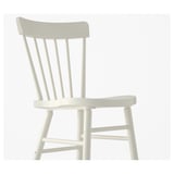 White spindle chair with curved back, solid wood legs, clean-lacquered for easy cleaning.