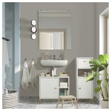 Modern small bathroom with white NORSÄLVEN storage cabinets and sink, grey towels, greenery, and minimalist decor.