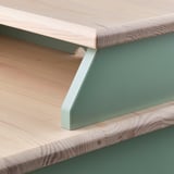 Scandinavian-style bedside table with natural wood top and green metal frame, showcasing craftsmanship and durability.
