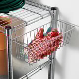 Metal shelf basket holding red floral-patterned gloves or mittens, part of the OMAR series.