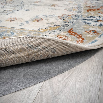 Close-up of a stylish, durable rug with faded patterns. Smooth pile and secure backing on wooden floor.