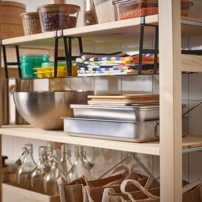 Kitchen shelf with PÅLYCKE basket of towels, jars, bottles, and burlap bags.