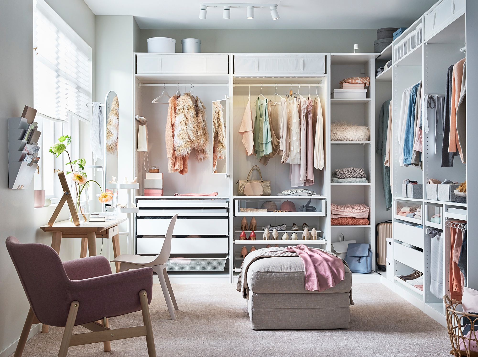Bedroom with white PAX wardrobe, chair, ottoman, and desk with flowers.