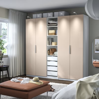 Beige PAX wardrobe with glass doors, organized storage.