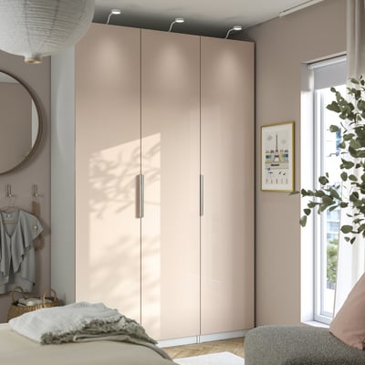 Modern bedroom with beige PAX wardrobe, mirror, and window.