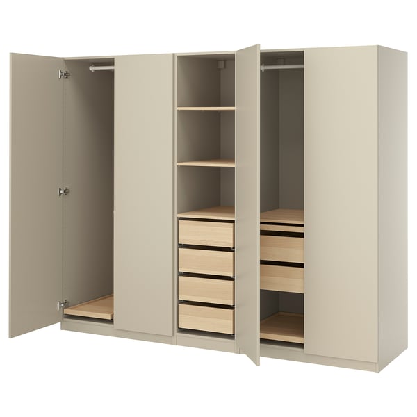 An open beige wardrobe named PAX. It shelving, drawers, and hanging space. The design is minimalist with a beige finish and wooden interior.