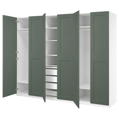 An open green PAX wardrobe with white shelves and partitions, displaying organized storage spaces.