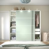 A modern closet with sliding doors, integrated lighting, and shelves for clothes and folded items.
