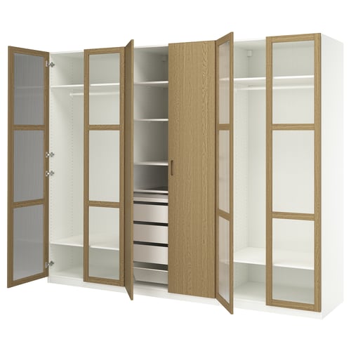 This image shows a white PAX wardrobe with oak-veneer doors, glass shelves, and metal drawers. It clothes rails and adjustable compartments.