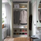 Open wardrobe with hanging clothes, shoes, and storage boxes.