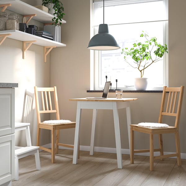 Small dining set with white table and light wooden chairs. Perfect for compact spaces.