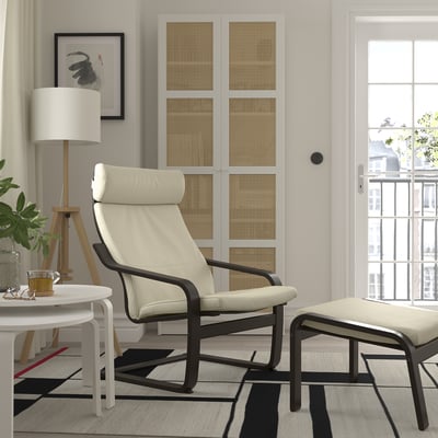 Modern living room with POÄNG chair, ottoman, black chair, rug, and natural light.