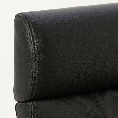Close-up of a stylish black leather chair, showing smooth grain texture and neat stitching, emphasising comfort and quality.