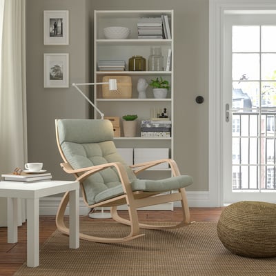 POÄNG rocking chair, light hue, beside window, cozy cushioned seat.