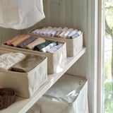 Organized shelves with folded clothes in fabric boxes, keeping items neat and accessible.
