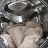 Washing machine drum with beige item, showing ease of cleaning.