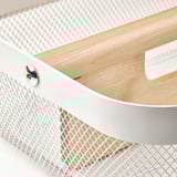 Close-up of white metal mesh storage with wooden divider detailing.