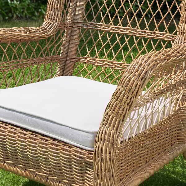Wicker hanging chair with cushion outdoors.
