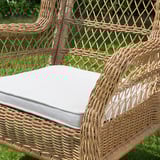 Wicker hanging chair with cushion outdoors.