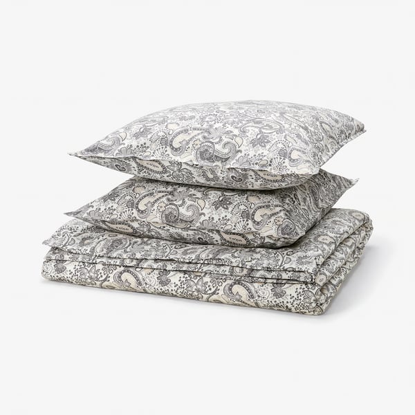 Stack of beige paisley bedding: duvet and two pillows, 80% cotton, 20% viscose, ornate floral pattern.