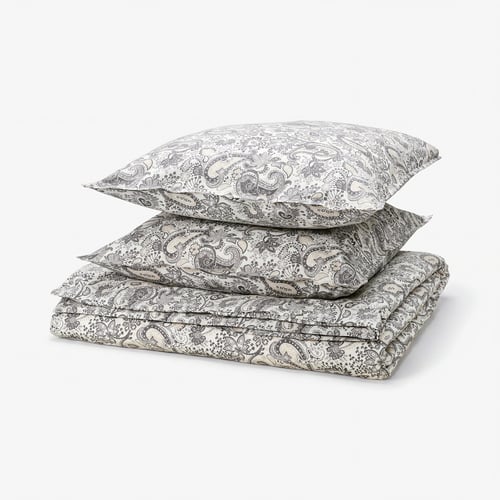 Stack of beige paisley bedding: duvet and two pillows, 80% cotton, 20% viscose, ornate floral pattern.