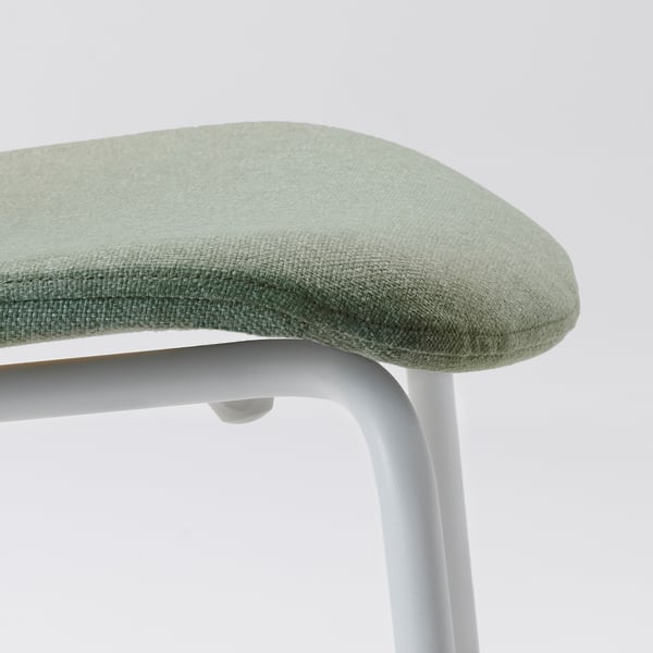 Close-up of a modern, light green, cushioned chair seat with sleek metal frame.