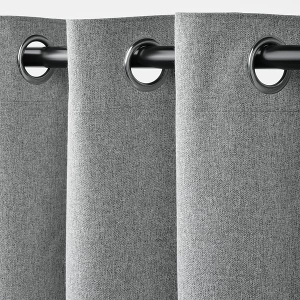 Close-up of grey curtains with metallic grommets, showcasing block-out functionality.