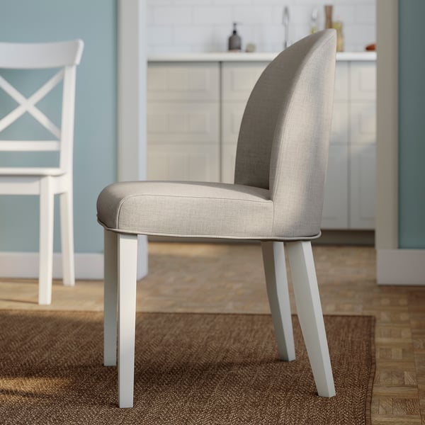 Modern grey fabric dining chair with white legs, supportive foam cushioning, elegant curved back in kitchen setting.
