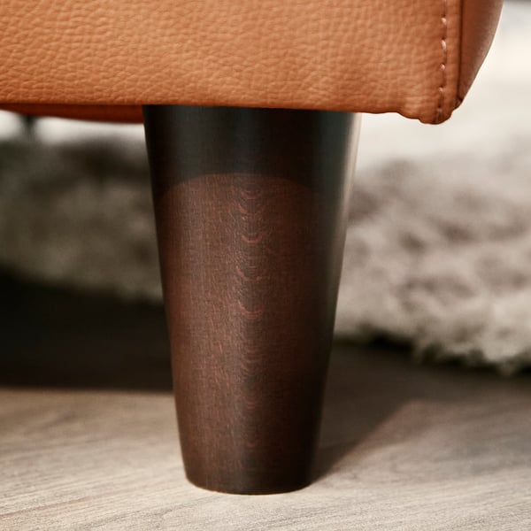 Modern brown leather chair leg, sleek & sturdy, part of a quality recliner.