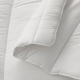 Close-up of soft, white, quilted duvet showing stitching detail.