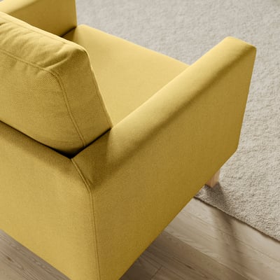 Modern yellow armchair with clean design, soft padded seat and back, on wooden floor.