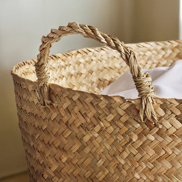 Handwoven basket with sturdy, twisted handles, showcasing intricate sedge weaving, perfect for home storage.