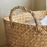 Handwoven basket with sturdy, twisted handles, showcasing intricate sedge weaving, perfect for home storage.