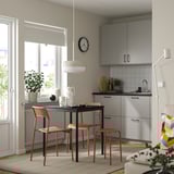 Modern kitchen with sandberg chair beside table by window.